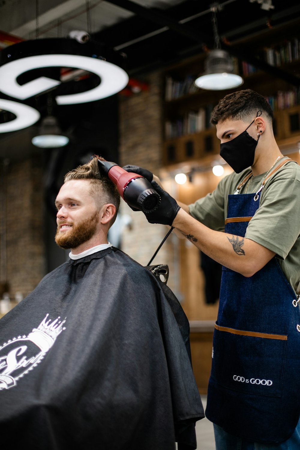 Coiffeur séchant les cheveux d'un client